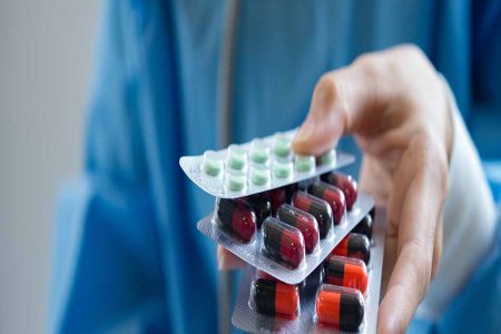 Woman pharmacist holding prescription medicine from doctor order